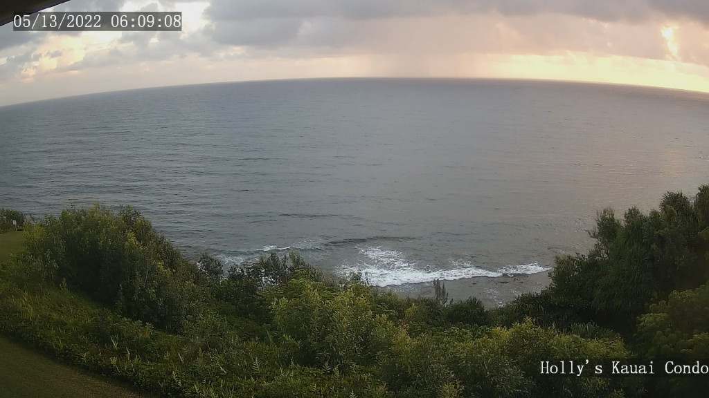 Web cam picture of a beautiful oceanfront sunrise with a squall dancing across the ocean.